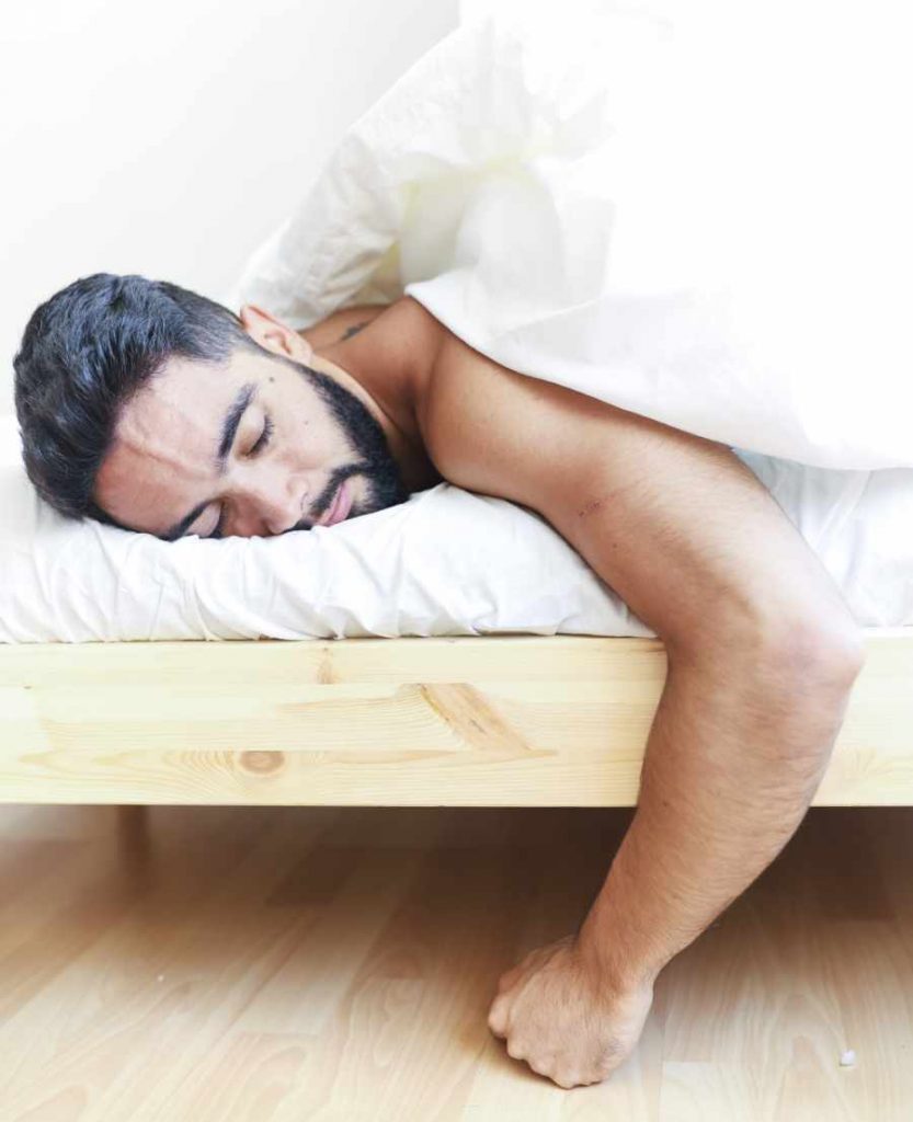 hombre en la cama con consecuencias de dormir mal